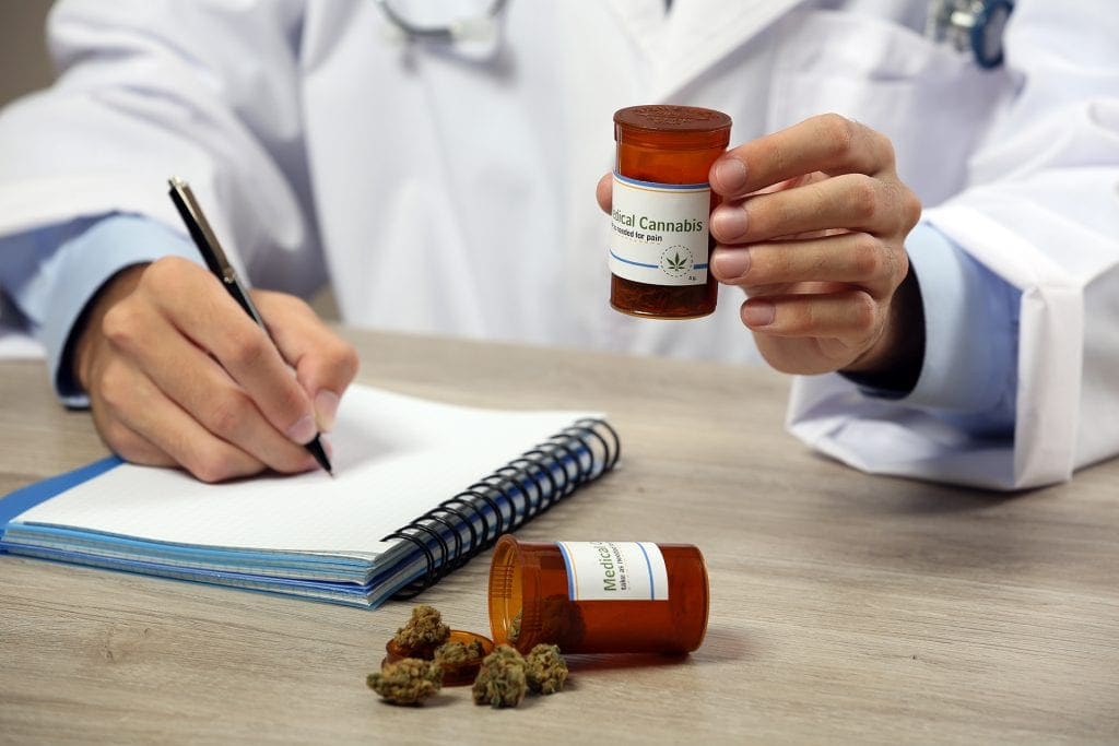 Doctor hand holding bottle with medical cannabis close up